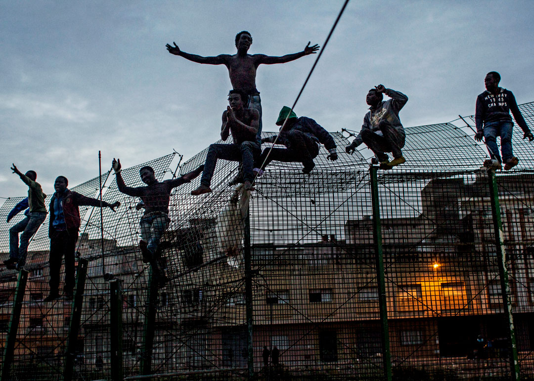 Sergi Cámara, Le Mur de l’Europe, Espagne, 2014.
<br>De jeunes Africains tentent d’escalader la double barrière qui sépare
l’Afrique de l’Europe, près de Beni Enza à la frontière de l’enclave espagnole
de Melilla en mars 2014. Après avoir passé plusieurs heures au sommet de la
barrière, ils ont été refoulés vers le Maroc par les forces de sécurité espagnoles.
Avec l’aimable autorisation de l’artiste